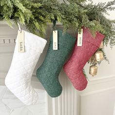 three christmas stockings hanging from a mantel