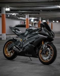 a black and gold motorcycle is parked in a parking garage with no one around it