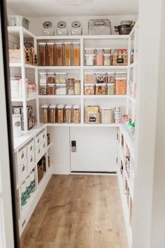 the inside of a kitchen with white shelving and wooden flooring in front of it