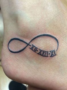 a small tattoo on the foot of a person with an infinite symbol and words written in black ink