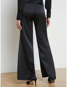 L'Agence Pilar Wide Leg Pant in black. Core L'Agence items are not stocked items and are placed by Steven Dann as we receive your order. Please allow 7-15 business days for this to ship. Not available for expedited shipping. High waisted. Wide leg. Flared hem. Belt loops. Side pockets. Back welt pockets. Front zip fly closure. Hidden hook and bar closure. This item runs long. Tailoring at the hem may be needed. 100% Silk. Rise: 11". Inseam: 34". Leg Opening: 14.4". Model Details: 5’10”| Bust: 34" | Waist: 23" | Hips: 34.5" | Wearing a Size 2. Imported. Dry clean. Resort Accessories, Silk Wide Leg Pants, Silk Pant, Elegant Pant, Perfect Pant, Pretty Fabric, Evening Look, Denim Coat Jacket, Silk Pants