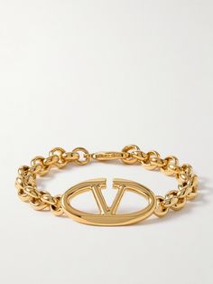 Valentino Garavani's bracelet is centered with the latest 'Bold' version of its 'VLOGO' emblem, which has curved edges. It's made from gold-tone metal and strung with chunky chain links, so it looks just as good solo or stacked with daintier styles. Designer Gold-tone Bracelets For Gift, Designer Yellow Gold Polished Bracelet, Designer Yellow Gold Jubilee Bracelet, Luxury Chain Bracelet With Logo Charm, Luxury Yellow Gold Chain Bracelet With Logo Charm, Yellow Gold Bracelet With Logo Charm, Designer Yellow Gold Jewelry With Jubilee Bracelet, Luxury Gold-tone Polished Chain Bracelet, Luxury Gold-tone Chain Bracelet With Polished Finish