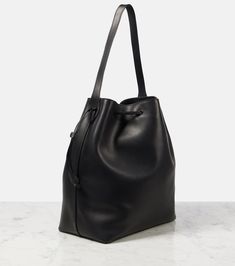 Belvedere leather bucket bag in black - The Row | Mytheresa Luxury Travel Bucket Bag, Modern Soft Calf Leather Bucket Bag, Evening Leather Bucket Bag, Modern Leather Bucket-shaped Hobo Bag, Modern Leather Hobo Bag In Bucket Shape, Calf Leather Shoulder Bucket Bag For Daily Use, Luxury Black Soft Leather Bucket Bag, Modern Black Bucket Bag With Leather Lining, Black Calf Leather Bucket Bag With Adjustable Strap