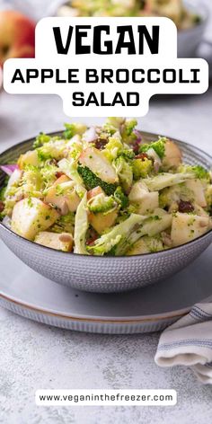 a bowl filled with broccoli salad on top of a white plate next to an apple