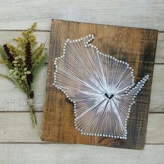 a piece of wood that has some string art on it