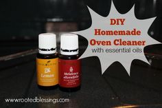 two bottles of essential oils sitting on top of a counter next to a sign that says diy homemade oven cleaner with essential oils