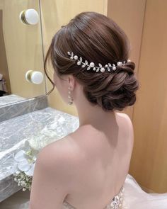 a woman in a wedding dress wearing a bridal hair comb with pearls on it