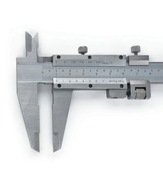 a caliper that has been placed on top of a white surface with a ruler attached to it