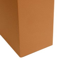 an orange square box sitting on top of a white floor next to a planter