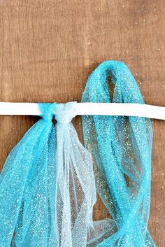 a piece of blue fabric tied to a white string on top of a wooden table