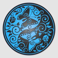 a blue and black plate with two dolphins in it's center, surrounded by swirls