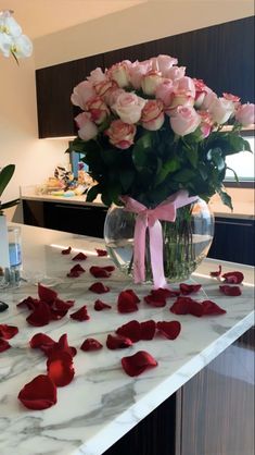 a vase filled with pink roses on top of a counter