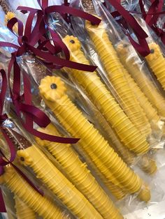 several pieces of corn are wrapped in cellophane and tied with red ribbon on display