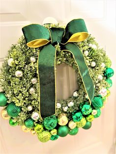 a christmas wreath with green and gold ornaments