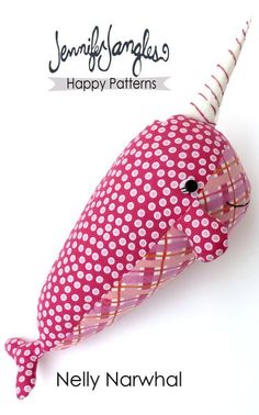 a pink and white whale stuffed animal with polka dots on it's head, sitting next to the words happy narwhale