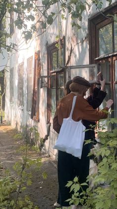 a woman holding a child in her arms and looking out the window at something outside