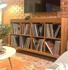 a living room with an entertainment center and brick wall