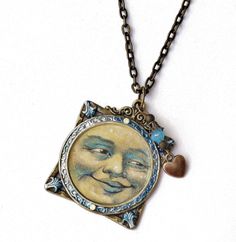 "A vintage style Boho necklace featuring an antiqued pendant framing a whimsical moon face with painted accents in violet and sapphire blue and tiny Swarovski crystal rhinestones adding sparks of opalescent light! A little heart charm dangles alongside, under a turquoise blue glass bead, and along the chain even more turquoise blue glass beads add more detailing! Just choose the length you would like this unique necklace to be and make it a part of your artful wardrobe! Antiqued Gold-plated Pend Antique Round Necklace With Moon Charm, Collectible Moon Charm Pendant Necklace, Antique Moon Charm Necklace As Gift, Antique Moon Charm Necklace For Gift, Antique Moon Charm Necklace Gift, Collectible Round Pendant With Moon Charm, Antique Moon Shaped Jewelry For Gift, Antique Moon Shaped Jewelry Gift, Antique Moon-shaped Jewelry Gift