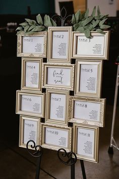 there are many frames with names and numbers on the easel for each place card