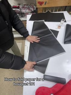 a person cutting out paper on top of a table