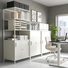 a room with a desk, chair and bookcases in the middle of it