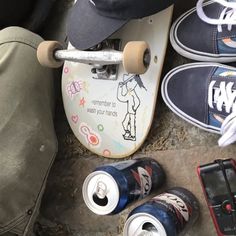 a skateboard, cell phone and other items are sitting next to each other on the ground