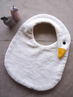 a baby bib laying on the floor next to a toy duck and another bird