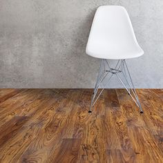 a white chair sitting on top of a hard wood floor next to a gray wall