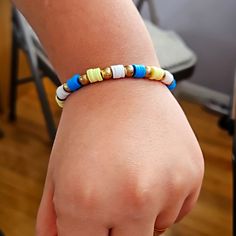 a close up of a person wearing a bracelet with colorful beads on their wrist and hand