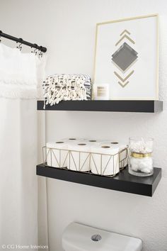 two black shelves above a toilet in a bathroom