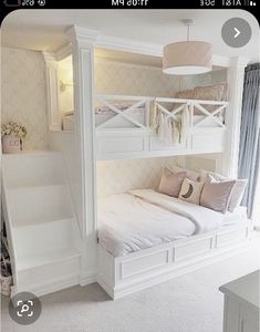 a white bunk bed sitting next to a window