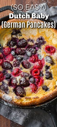 a dutch baby cake with berries and powdered sugar