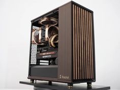 a computer case sitting on top of a black stand with gold trim and fan blades