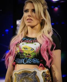 a woman with pink hair holding a wrestling belt