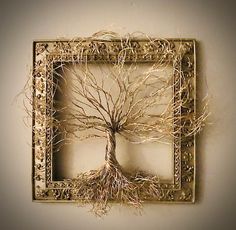 a metal frame with a tree in the middle and roots on it's sides