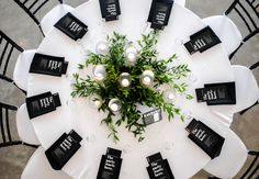 a white table topped with lots of black and white tables cloths covered in candles