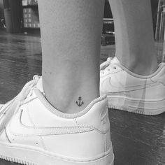 a woman's foot with a small anchor tattoo on her left ankle and lower leg