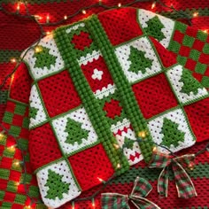 a crocheted christmas blanket with lights on it