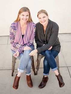 two women sitting on chairs smiling for the camera