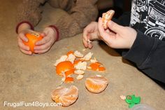 two children are peeling oranges on the counter top with one child's hands