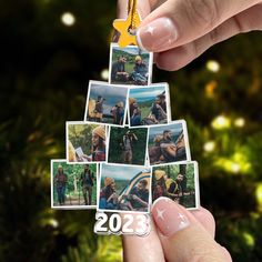 a hand holding a christmas tree ornament with pictures on it and a star hanging from the top