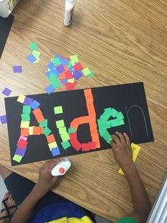 a child is making letters out of construction paper