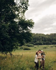 two people standing in a field hugging each other