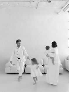 a black and white photo of a family playing in the living room with their children