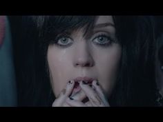 a close up of a person eating food with her hands on her mouth and two other people in the background