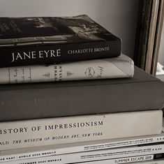 a stack of books sitting on top of each other next to a window sill