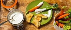 carrots, celery, and other vegetables on a plate with ranch dressing