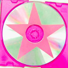 a pink and green cd with a star in the middle on it's side