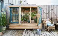 a small wooden building with plants in it