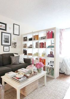 a living room filled with furniture and bookshelves next to a white coffee table